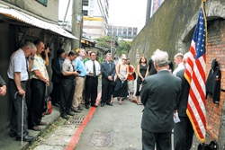 Charles Parker, left, brother of an airman executed by the Japanese soldier on May 29, 1945, touches his head in grief during a prayer held yesterday in front of a US Navy uniform hanging on the old Taipei Prison wall on Chinshan South Road, about a block south of Hsinyi Road on the west side of the street. Fourteen U.S. POWs were executed by the Japanese 57 days prior to the end of WWII.  / RICK YI, TAIWAN NEWS